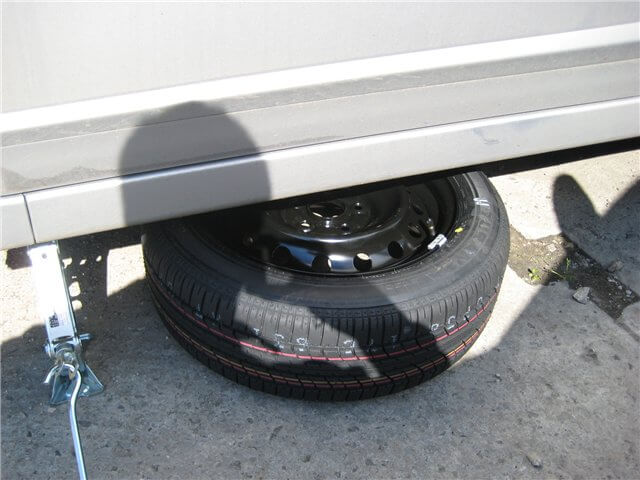 Запасное колесо подложенное под порог автомобиля